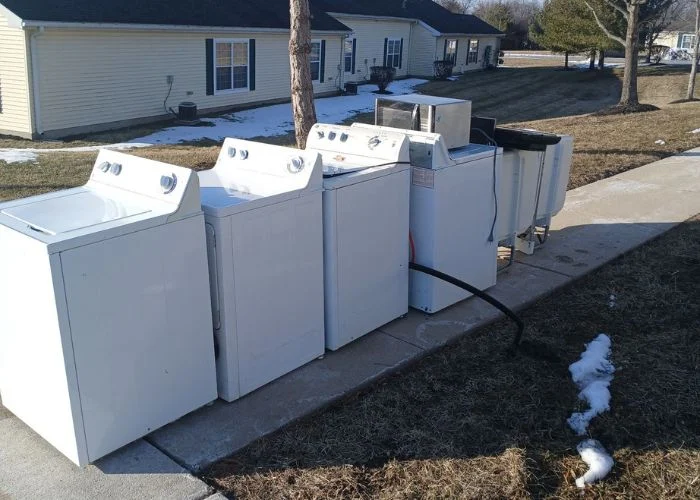 Used washers and dryers staged outside
